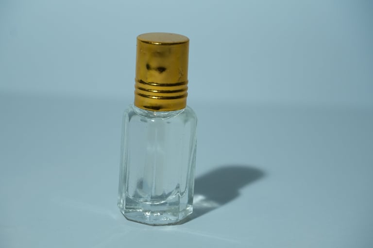 Luxury perfume bottle with golden cap on pink background